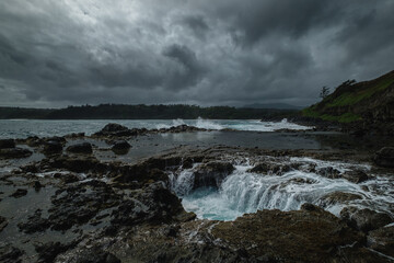 a rocky beach with a cloudy sky