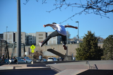 Skateboarder up in the air doing tricks in a skatepark.