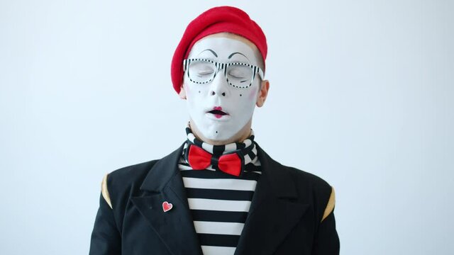 Slow motion portrait of sleepy mime with closed eyes yawning covering mouth with hand then looking at camera. Sleepiness and pantomime concept.