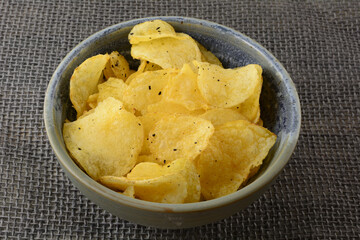 Italian Black Truffle Potato Chips in ceramic bowl on burlap