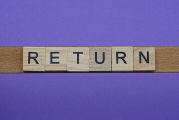 gray word return in small square wooden letters with black font on a lilac background