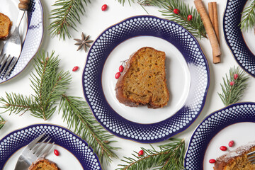 Fototapeta na wymiar Slices of bundt cake on plates in festive arrangement, top view