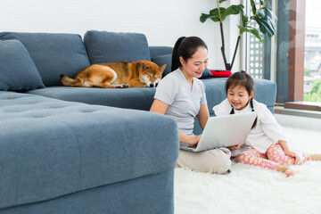 Asian mother and daughter spend their vacations in the living room.