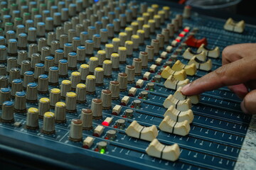 Audio sound mixer with focus to the man's hand moving the slider