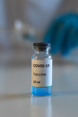 Concept of Covid 19 vaccine vaccinating, development and creation, doctor or scientist in laboratory holding a single dose of  2019-ncov vaccine, a syringe and ampule with SARS-CoV-2 vaccination