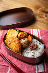 japanese style bento in wooden box with meat ball and croquette