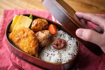 japanese style bento in wooden box with meat ball and croquette