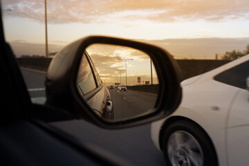 car view mirror on sunset. sunset car driving scene.