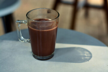 Fresh drink in the morning with a glass of hot chocolate on the table. a cup of hot chocolate to relax in the morning