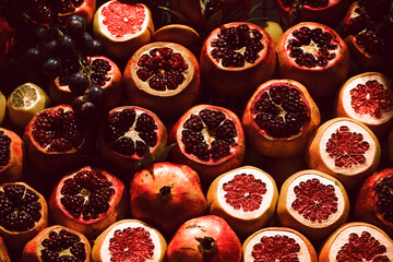 Red ripe pomegranates in the oriental bazaar are sliced ​​to make freshly squeezed juice.