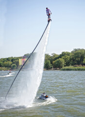  The athlete flies with a water jet from the side of a water motorcycle in front of the audience at...