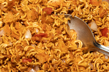 Spicy instant noodles with onion and tomatoes is popular in South Asia as fast or junk food also called as chatpate locally