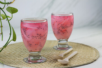 Es Jelly Kelapa Muda or Young coconut ice syrup, Indonesian popular drink, especially for breakfasting during ramadan month. Grainy from the glass. White marble background.