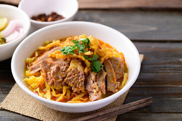 Northern Thai food (Khao Soi), Spicy curry noodles soup with beef eating with pickled mustard, shallot, lime and ground chili fried in oil