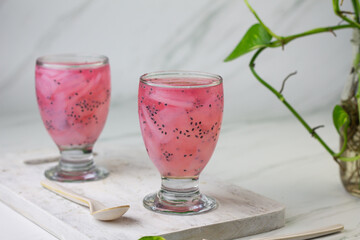 Es Jelly Kelapa Muda or Young coconut ice syrup, Indonesian popular drink, especially for breakfasting during ramadan month. Grainy from the glass. White marble background.
