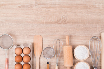 Fototapeta na wymiar Kitchen utensils and food ingredients for bakery cooking on wooden table background, Top view