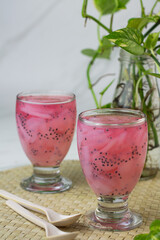 Es Jelly Kelapa Muda or Young coconut ice syrup, Indonesian popular drink, especially for breakfasting during ramadan month. Grainy from the glass. White marble background.