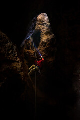 Rescuers or climber descends in a cave fast rope in the dark caves