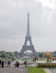  View of the bridge Jena and the Eiffel Tower. In the foreground, tourists are photographed in the background of the tower