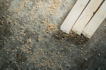 The process of making joints wood lath in the carpentry workshop. Raw pinewood and sawdust on the concrete floor.