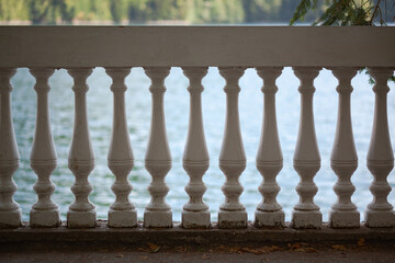 White stone railings with balustrades, in the background of the pond