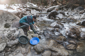 Outdoor adventures on river. Gold panning. Searching for gold in a mountain creek in the winter...