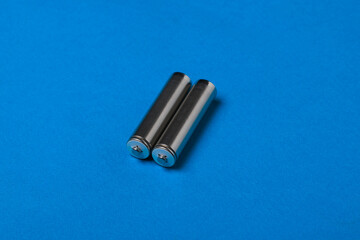 Naklejka premium Two AA batteries on a blue background.