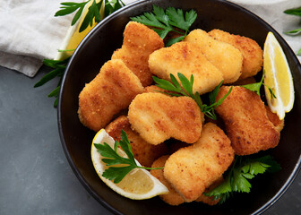 Crispy chicken nuggets on grey background.