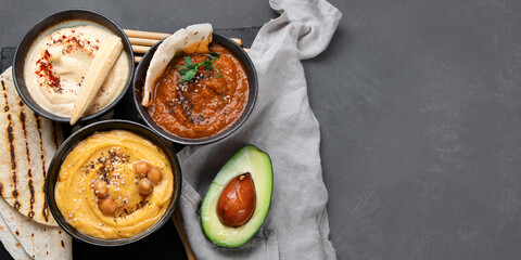 Different kinds of hummus dips with snacks