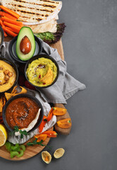 Different kinds of hummus dips with snacks
