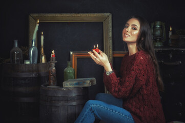Young woman with candles on a dark background.Esoteric astrology forecast, superstition, magical...