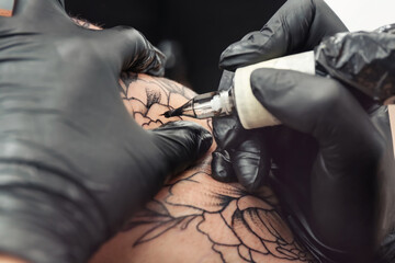 Professional artist making tattoo in salon