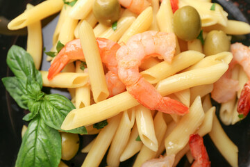 Plate of tasty pasta with shrimps and olives, closeup
