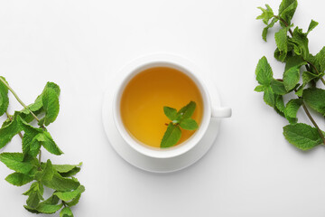 Cup of tasty mint tea on white background