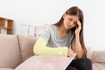 Young woman with broken arm at home