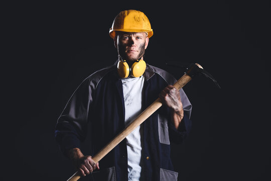 Miner man with pick axe on dark background