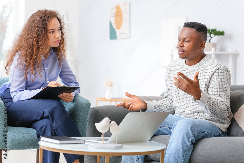 Wall mural Psychologist working with African-American man in office