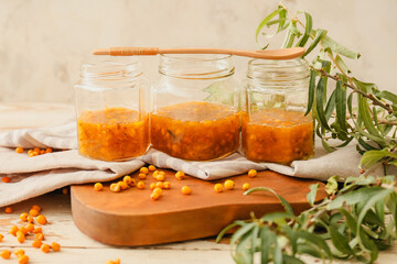 Tasty homemade sea buckthorn jam on table