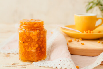 Tasty homemade sea buckthorn jam on table