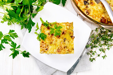 Casserole of meat and eggplant in plate on board top