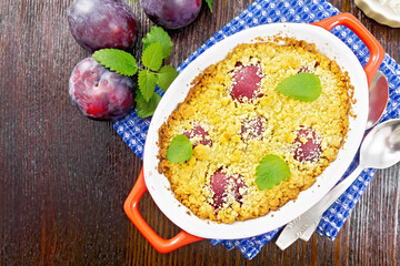 Crumble with plum in brazier on board top
