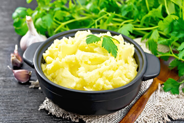Potatoes mashed in saucepan on board
