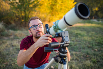 Amateur astronomer looking at the sky with a telescope.