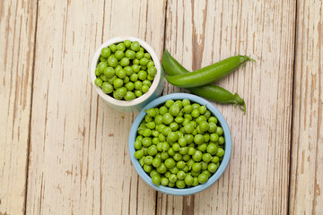Green peas on vintage white wooden table background