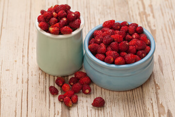 Red organic strawberries on white wooden board background, organic food concept