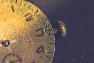 Vintage wall clock on a dark background. Selective focus. Vintage light toning. Grunge style backdrop
