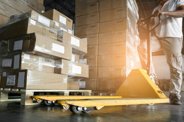 Worker working with hand pallet jack unloading cargo boxes at the warehouse storage. shipment boxes - obrazy, fototapety, plakaty
