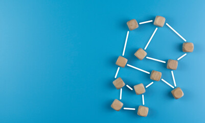 The concept of building relationships. Wooden cubes connected by lines. Blue background