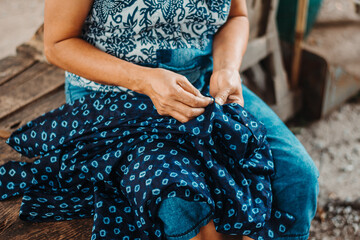 An artist of long experience is sewing the beautiful natural dye indigo.