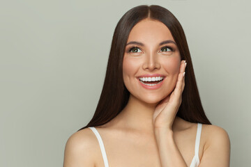 Happy surprised woman spa model with clear skin and long healthy straight hair. Skincare and facial...